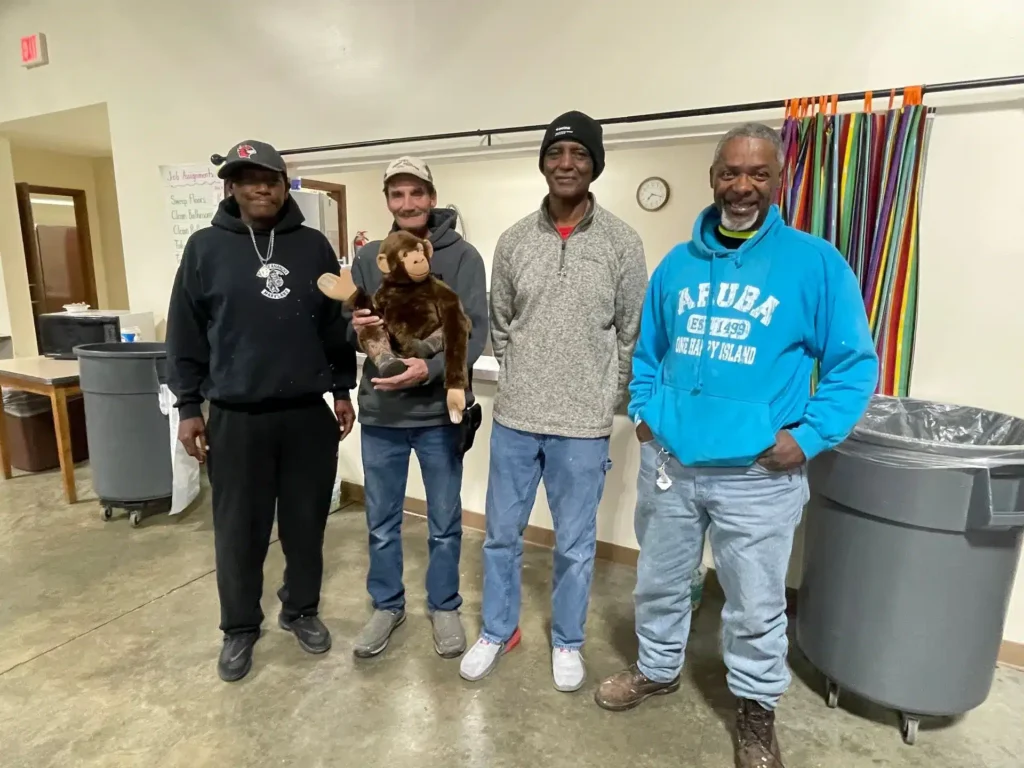 Shelter residents Stacey Turner, Creston Pumphrey, check-in manager Jerry Palmer and shelter resident Kendall Bibbins are in front of the kitchen area.