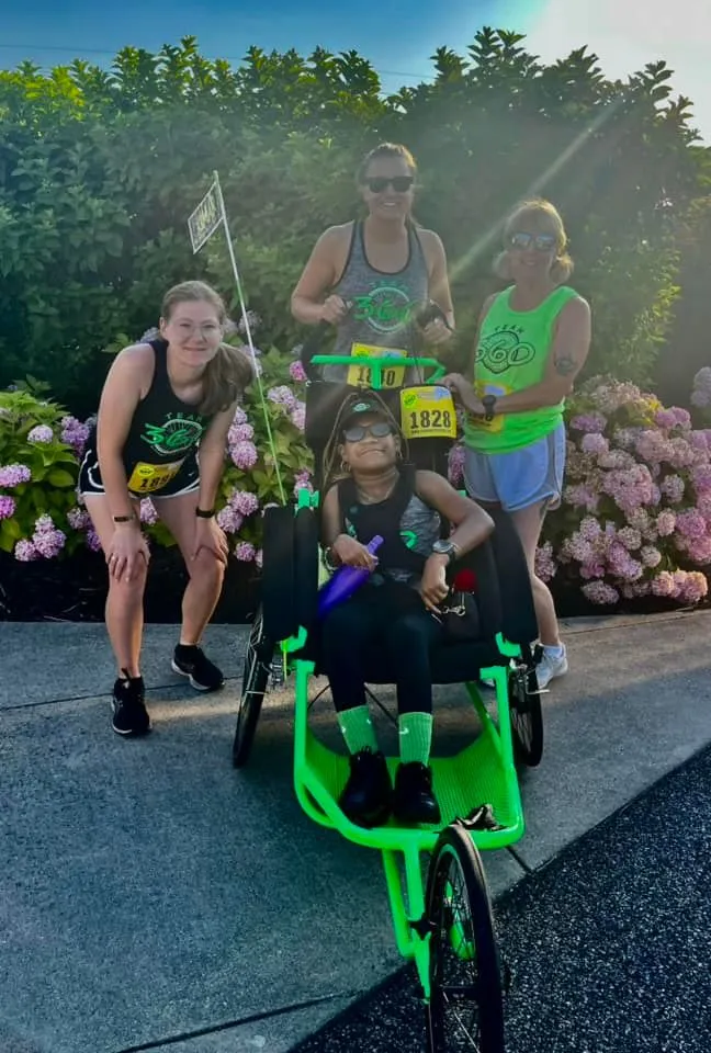 Wingmen Claire Moreno, Elizabeth Johnson and Carol Walston helped athlete Kimar Holcey cross a finish line at a 5K last month.
